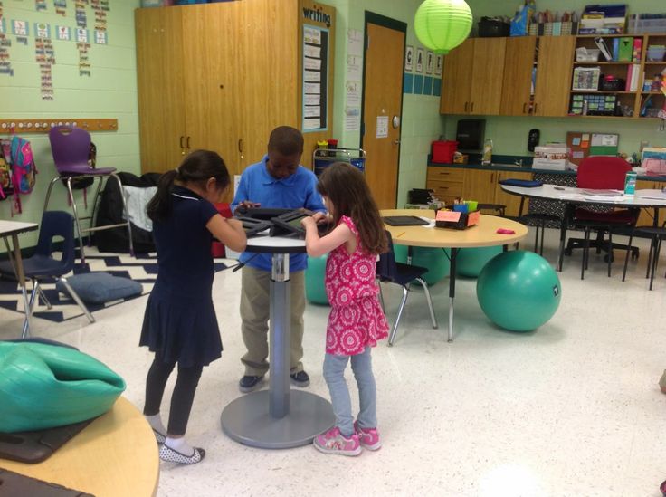 This is an image of students standing and collaborating at a table